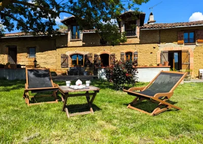 Photo d'un petit déjeuner servi sur le salon de jardin avec vue sur la ferme.