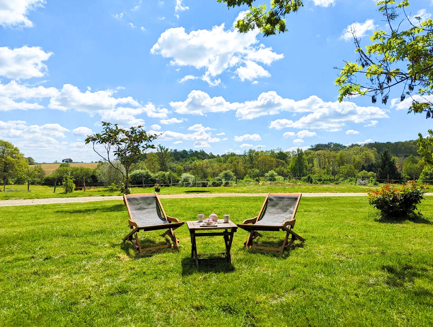 Photo du salon de jardin en chambre d'hôtes et vue sur la campagne avec petit déjeuner (boisson chaude et gâteaux chocolat).